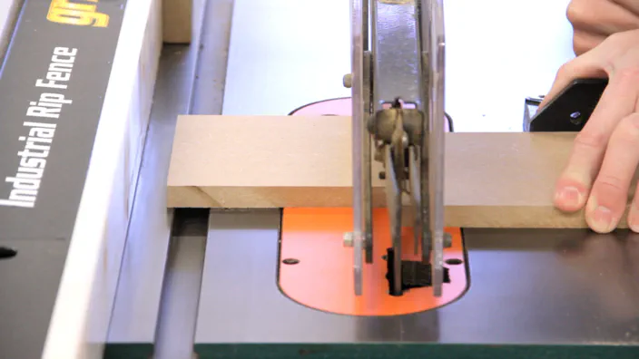 A table saw is used to cut a small sheet of MDF.