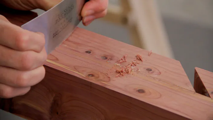 A card scraper is used to remove glue on a cedar skateboard rack.