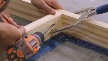 A pocket hole clamp and drill are used to screw together the frame.