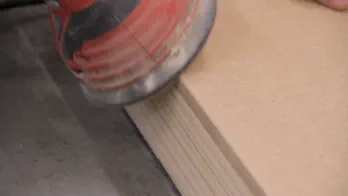 A sander is used to round over an MDF edge.