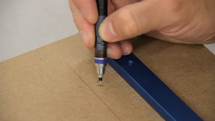 A pencil is used to mark hole locations on MDF.