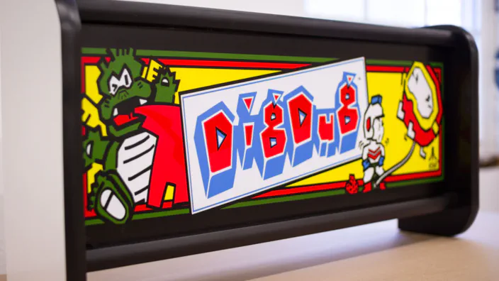 A lit Dig Dug arcade marquee.