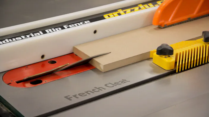 A piece of MDF is cut into a French cleat on a table saw.