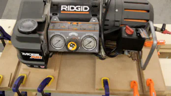 An air compressor is used to weigh down MDF.
