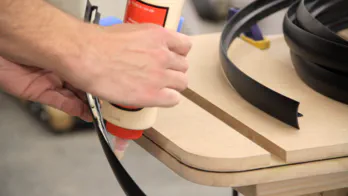 Glue is applied to plastic T-molding.