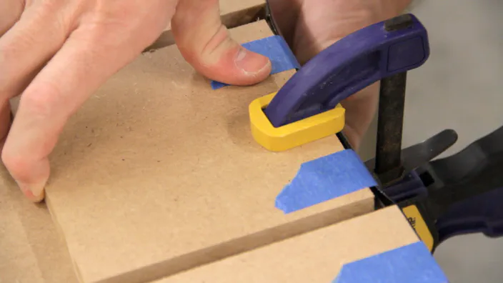 Tape is applied to secure plastic T-molding in place.