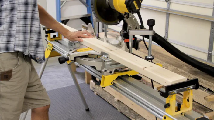 A 2x4 is cut using a power miter saw.