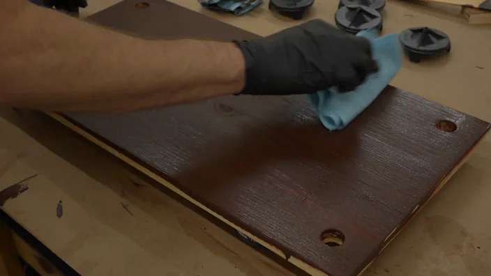 Gel stain is applied to wooden shelving.