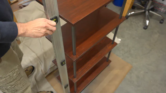 A large level is used to check that the top shelf is placed properly.
