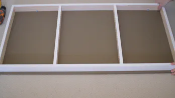 The frame is laid on the bottom of the shelf.