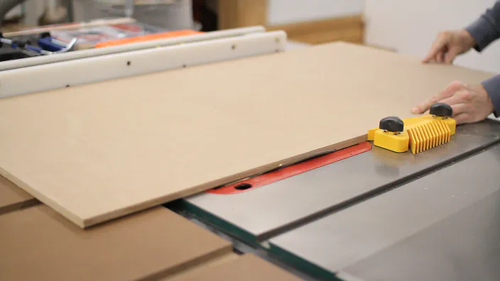 A table saw is used to cut a bevel down a piece of MDF.