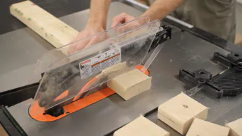 A table saw is used to cut a 2x4 into small blocks.