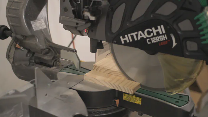 A miter saw is used to cut a pine board.