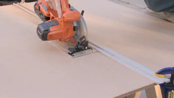 A circular saw is used to cut a large sheet of MDF.