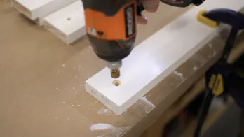 A cordless drill is used to drill countersunk holes.