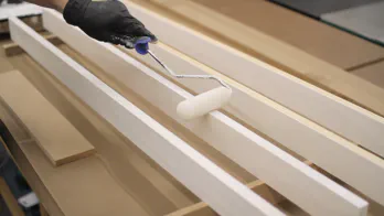 A 4" roller is used to apply primer to the legs.