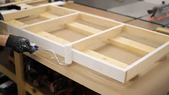 A 4" roller is used to apply primer to a frame.