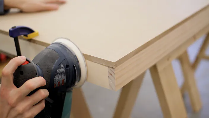 A random orbit sander is used to sand two pieces flush.