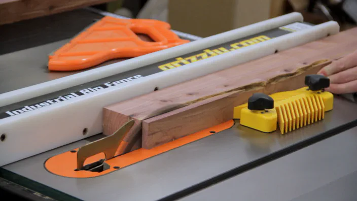 A table saw is used to rip a cedar board to width.