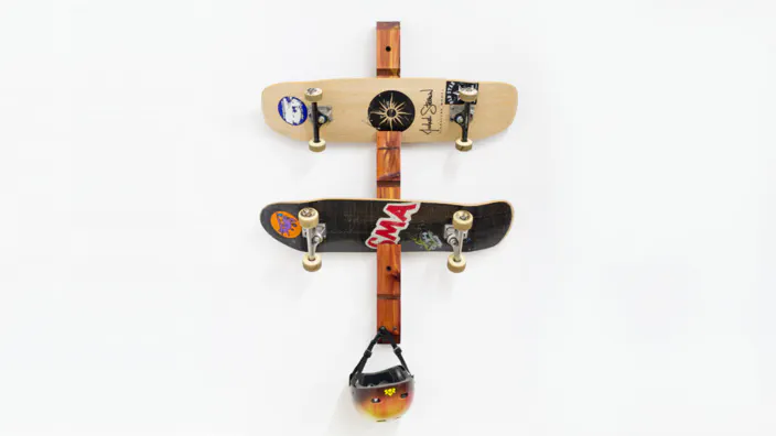 A wooden skateboard rack, skateboards, and helmet.