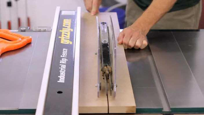 A long piece of MDF is cut at the table saw.