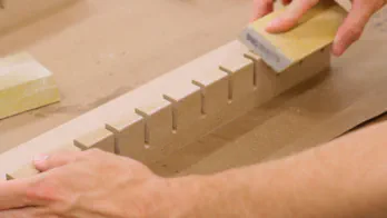 A sanding pad is used on the front edge of the rack.