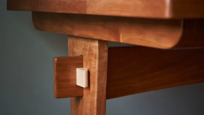 A trestle desk made of cherry wood with maple wedges.