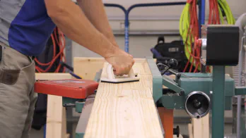 A jointer is used to flatten the face of a piece of lumber.