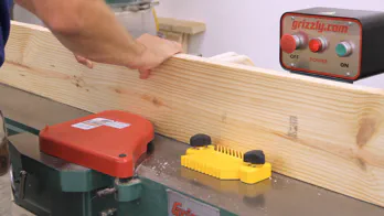 A jointer is used to flatten the edge of a piece of lumber.