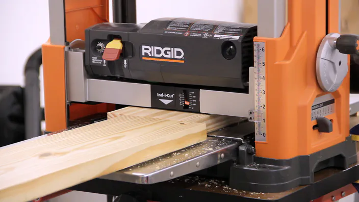 A planer is used to surface a piece of lumber.