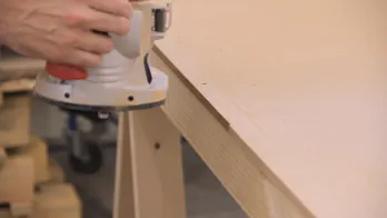 A router is used to trim the edge of a piece of MDF.