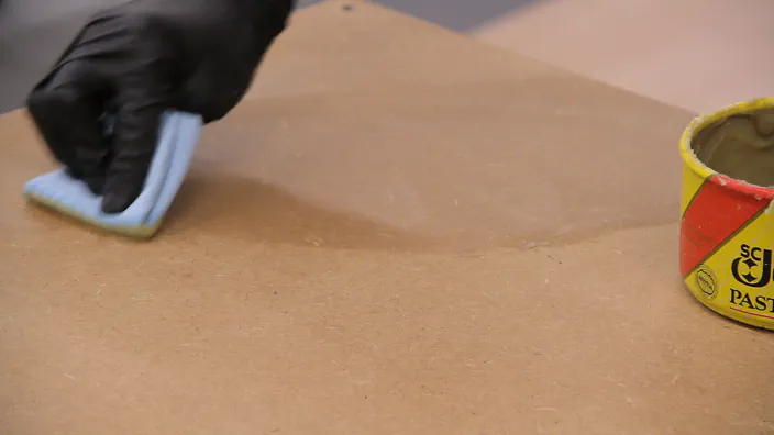 Paste wax is applied to an MDF shelf top.