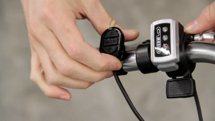 Electric bicycle throttle controls are attached to the left handlebar.