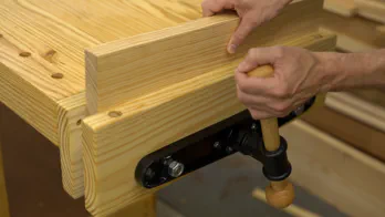 A board is clamped in the vise.