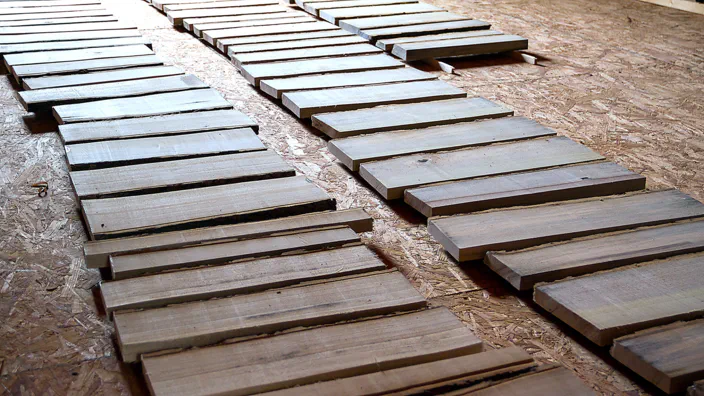 Many short boards are spread out on a floor.